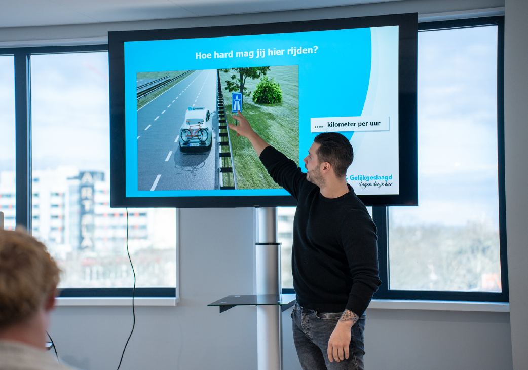 Docent legt tijdens de theorie cursus Almelo uit hoe hard je mag rijden