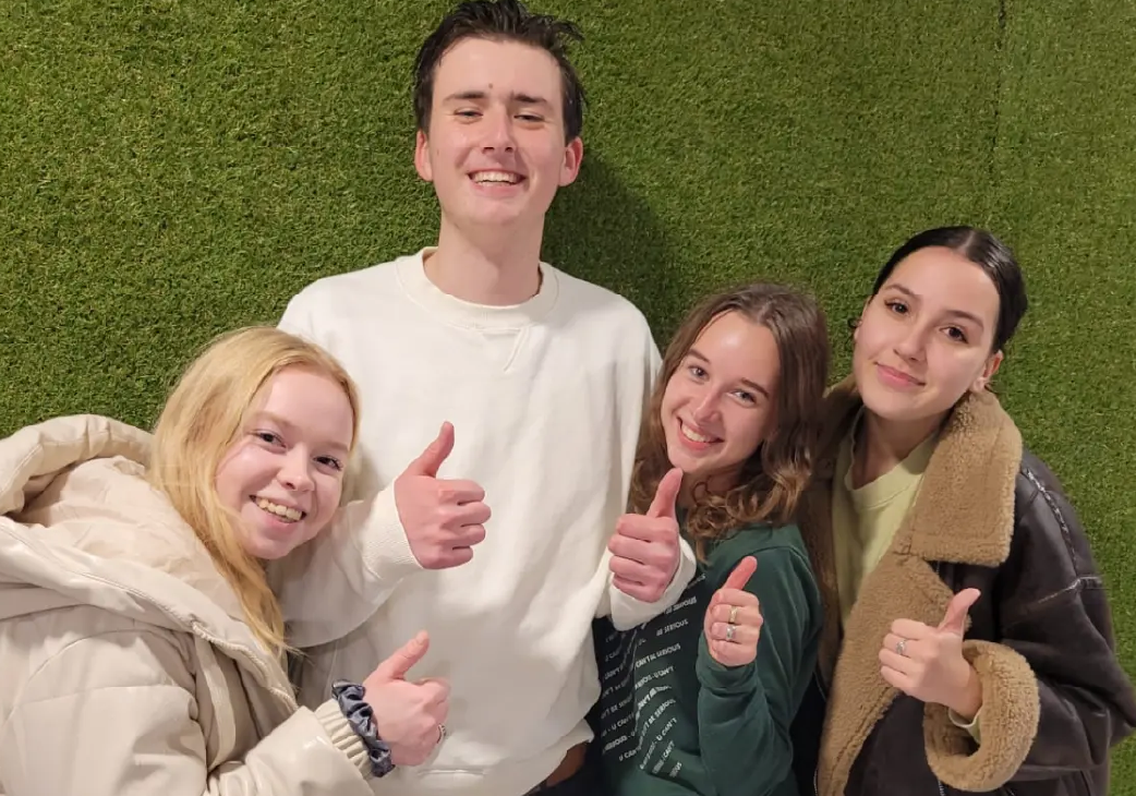 Drie meiden en een jongen met duim omhoog na de theorie cursus Leidschendam
